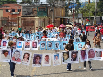 Miembros de COFADEH llevando los rostros de las víctimas del Golpe